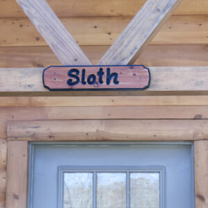 Sloth Cabin sign hanging above door